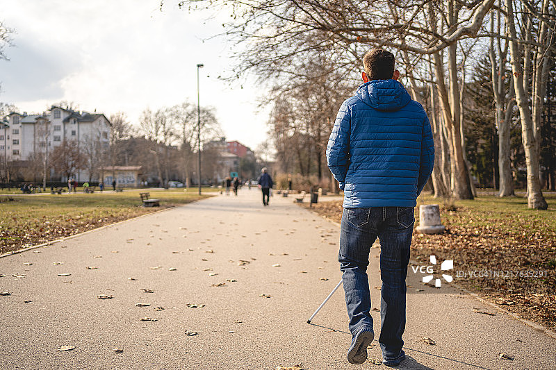 一名失明的男子在公园享受清晨散步图片素材