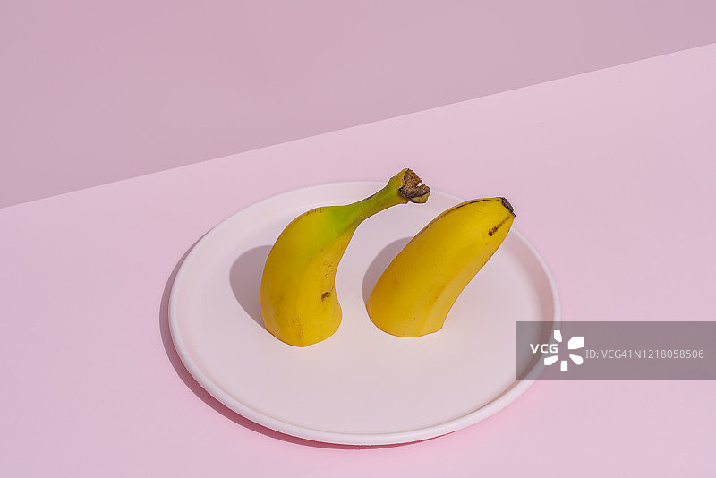 粉色盘子里切成两半的香蕉图片素材
