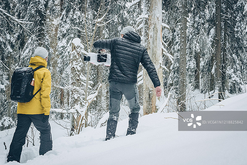 朋友们带着摄像机徒步穿越雪地图片素材