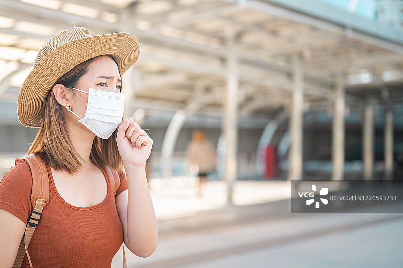 年轻的亚洲女性旅行者戴着防护面罩，以防止细菌和病毒在城市的传播图片素材