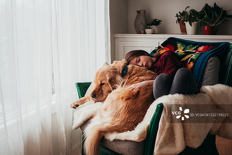 一个女孩和她的狗睡在沙发上图片素材