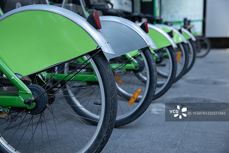近距离观看组绿色自行车车轮免费出租在停车场。图片素材