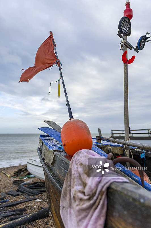 迪尔，英国肯特，2012年12月30日。迪尔海滩上有浮标和旗帜的旧渔船。图片素材