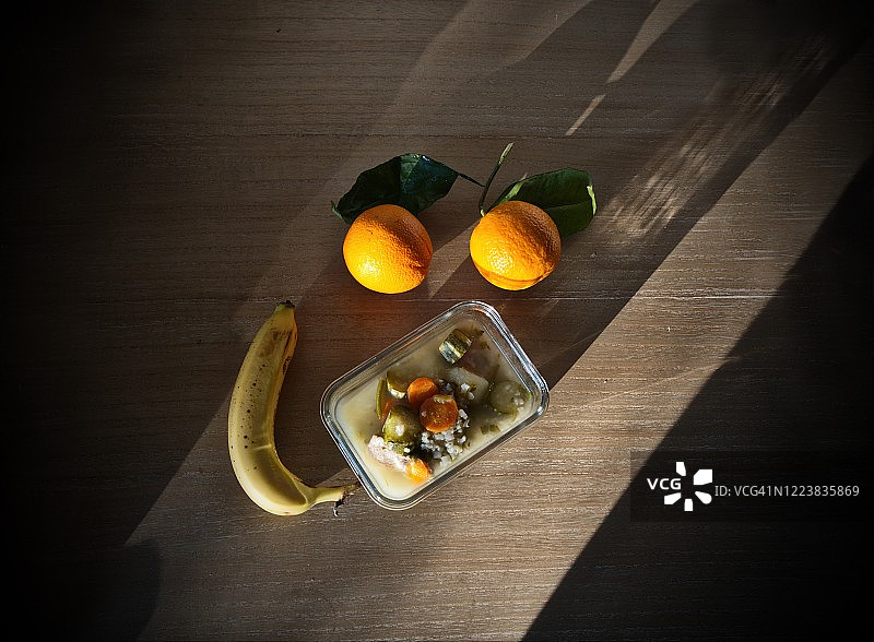 橙子、香蕉、小胡瓜、米饭和胡萝卜放在木桌上图片素材