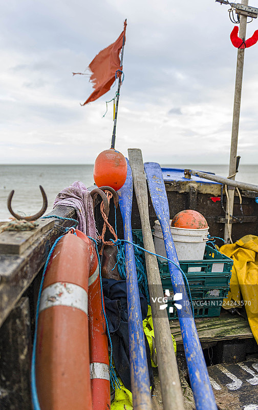 迪尔，英国肯特，2012年12月30日。迪尔海滩上有浮标和旗帜的旧渔船。图片素材