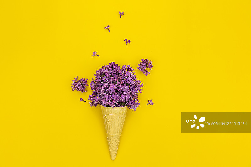 冰淇淋蛋筒与春天的丁香花在黄色的背景图片素材