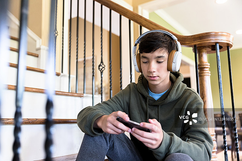 青少年戴蓝牙耳机玩网络游戏图片素材