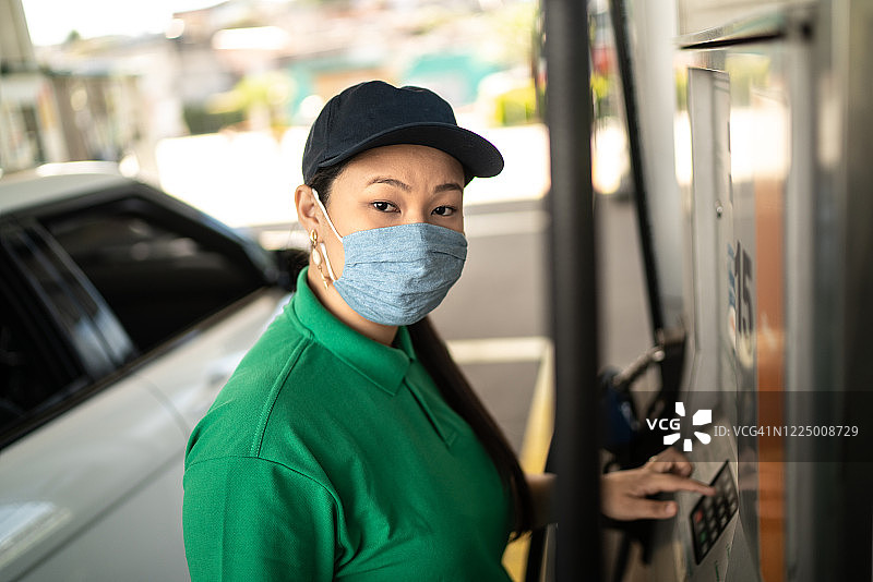 加油站女服务员戴口罩工作的肖像图片素材
