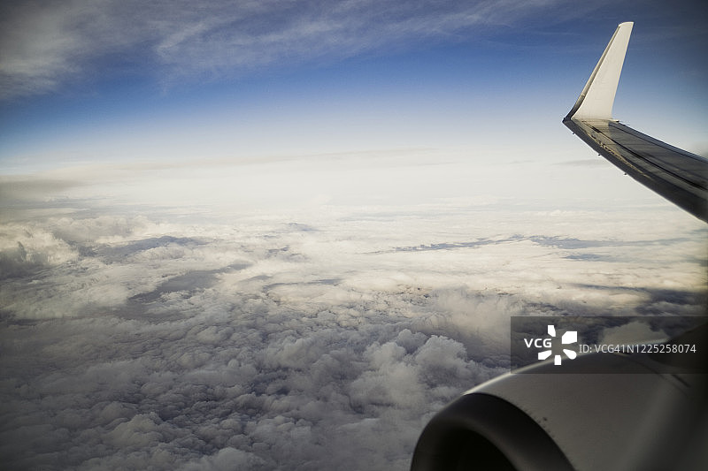 飞机机翼在云层上方飞行的图像图片素材