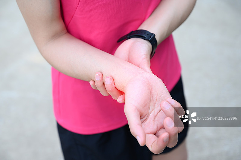 近距离的女人握着她的手腕，因为手腕疼痛。图片素材