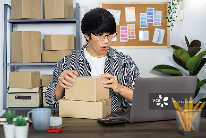 亚洲人企业家创业小型企业企业家中小企业自由职业者与盒子工作到网上营销包装和送货现场在家办公，网上企业卖家的概念图片素材