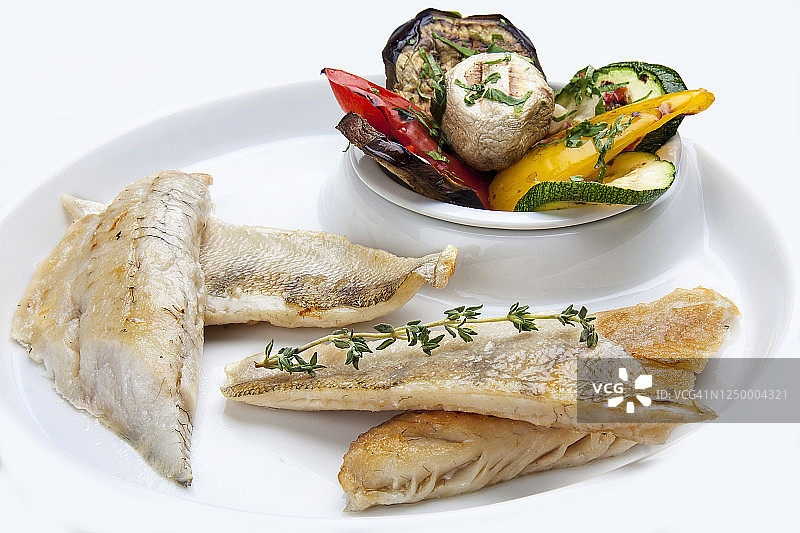 鲈鱼片配烤蔬菜，白色背景图片素材