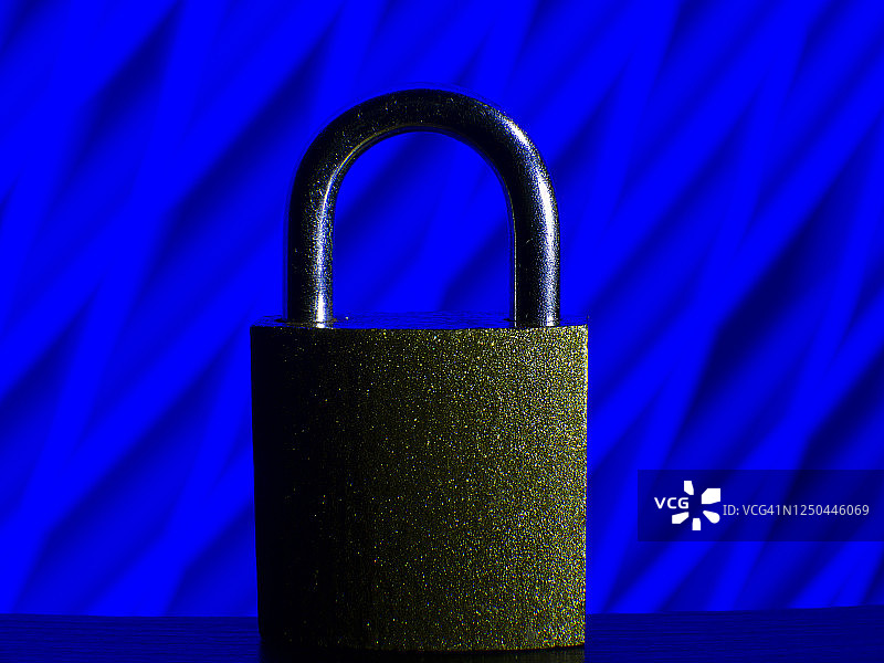 一个封闭的挂锁的特写与未来的蓝色背景。图片素材