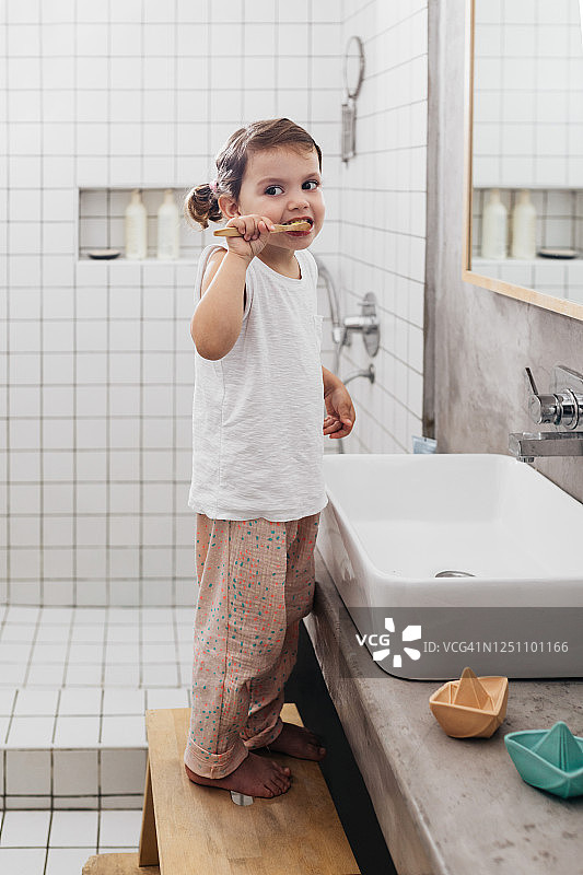 一个可爱的白人女孩在浴室里刷牙图片素材
