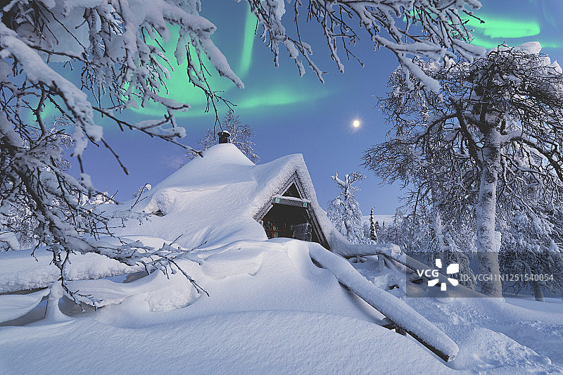 芬兰拉普兰的北极光中的雪小屋图片素材