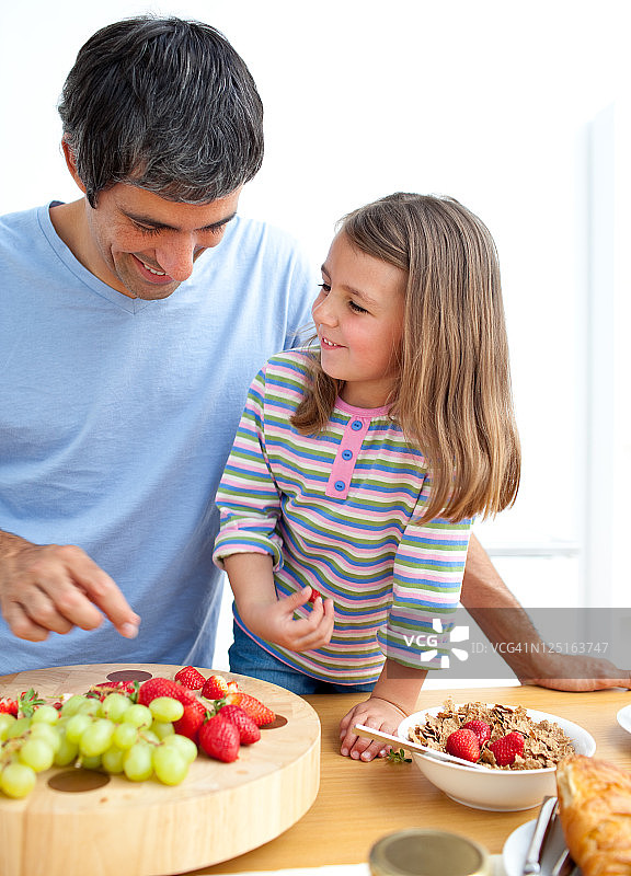 快乐的父亲和他的女儿正在吃早餐图片素材