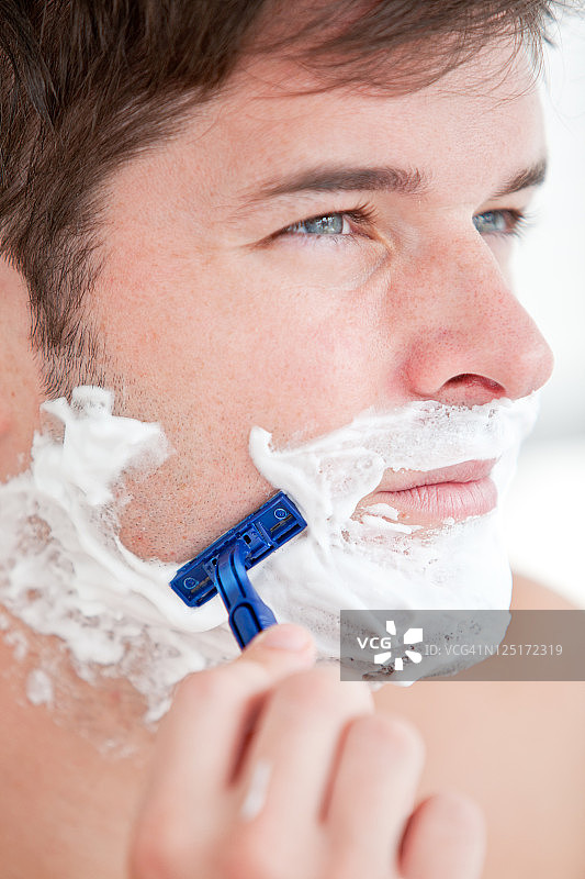 聪明的男人在浴室里刮胡子图片素材