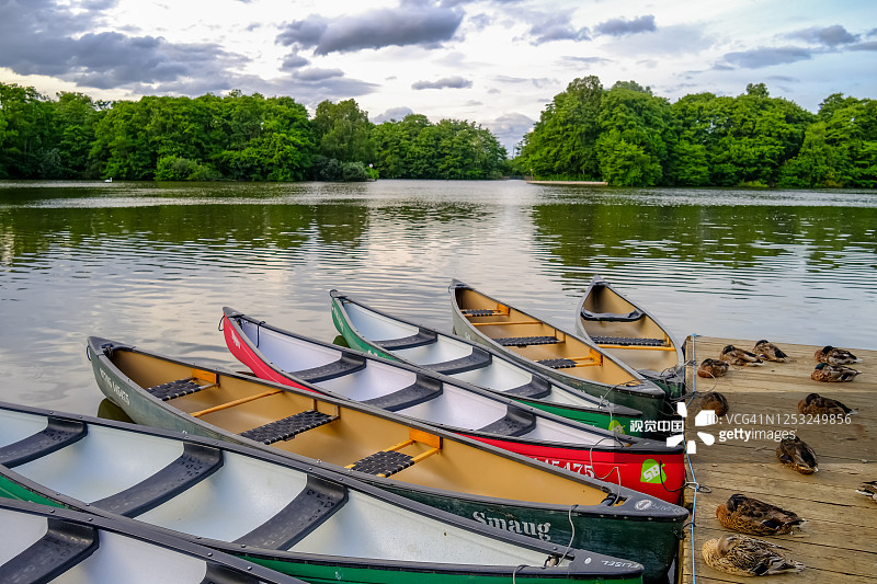 在英国的乡村，皮划艇被绑在装有熟睡的鸭子的木船上图片素材