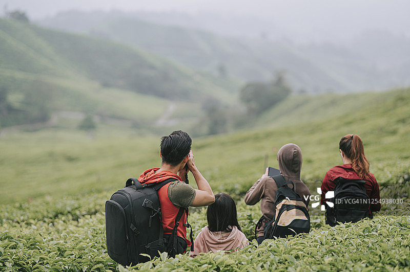一名亚洲中国游客在卡梅伦高地茶园享受大自然的美丽和清晨清新的空气，与他的家人合影图片素材