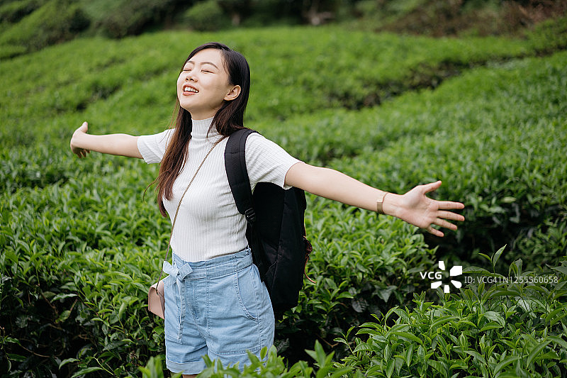 年轻的亚洲女人与背包探索茶园图片素材