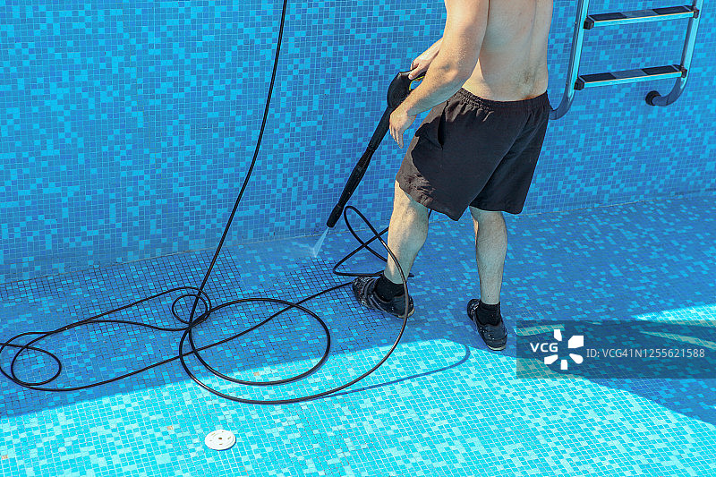 工作人员用喷水器清洁酒店的游泳池图片素材
