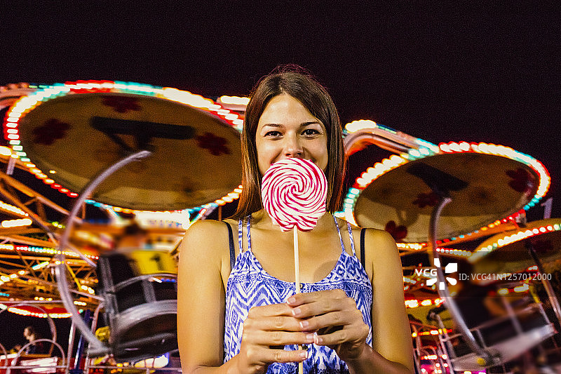 在游乐园吃棒棒糖的女人图片素材
