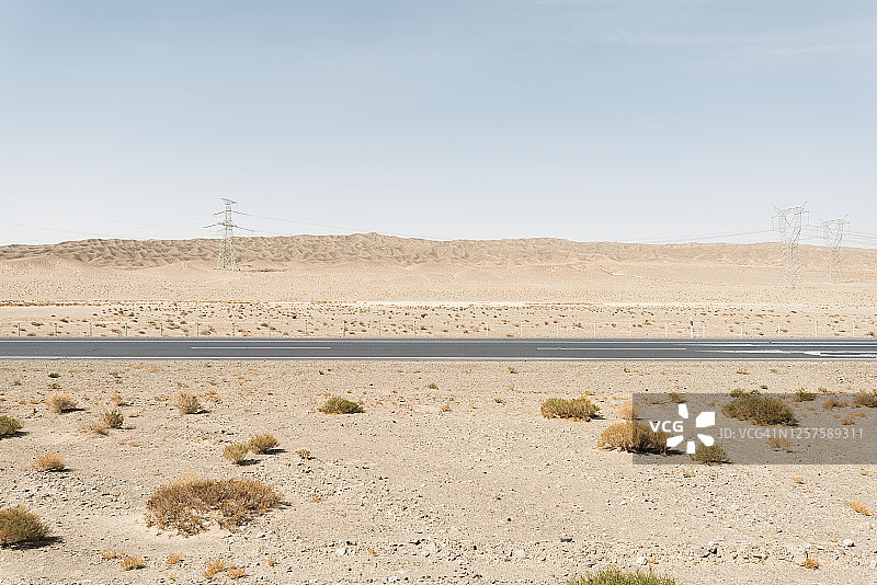空旷的柏油路穿过沙漠图片素材