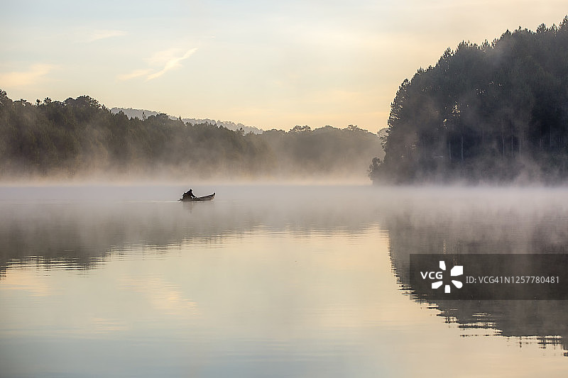 孤渔夫日出在雾湖上垂钓的抽象图片素材