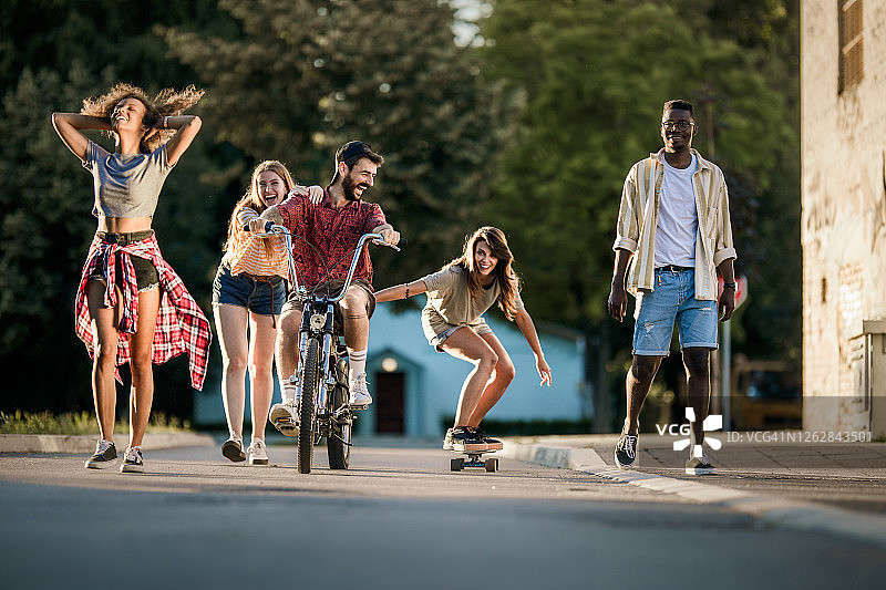 年轻快乐的千禧一代朋友在街上玩。图片素材
