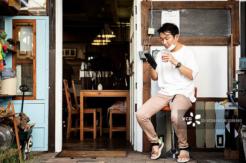 一个男人在咖啡店门口喝着茶放松图片素材
