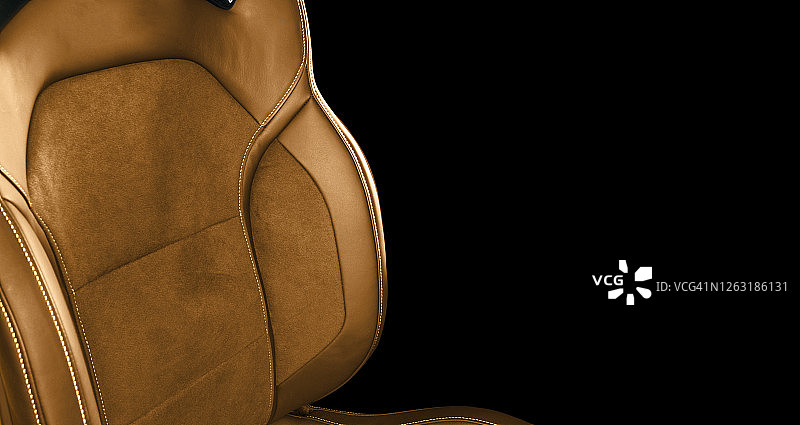 豪华现代汽车的棕色皮革内饰。穿孔棕色皮革舒适座椅与缝线隔离在黑色背景。现代汽车内部细节。汽车详细。汽车内部图片素材