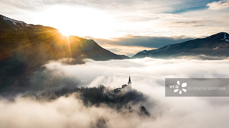 在山上俯瞰迷雾山谷的教堂图片素材