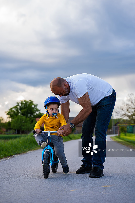 父亲和儿子花时间在户外，玩自行车图片素材