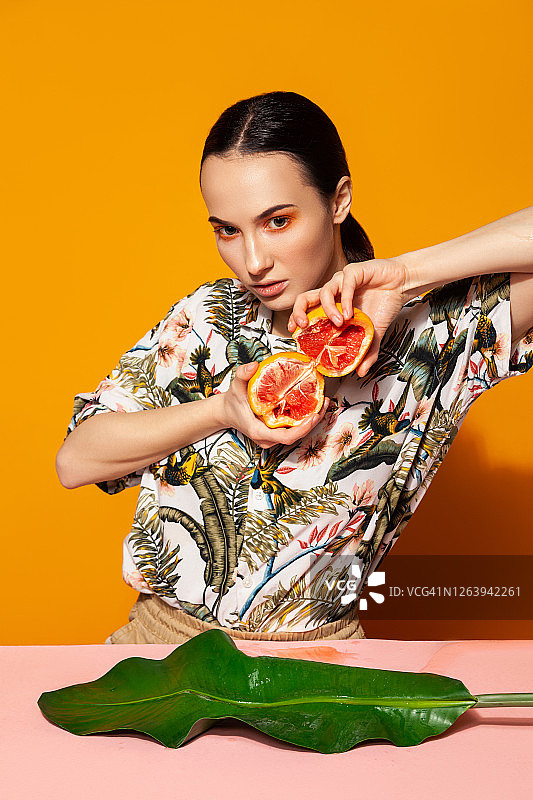 柚子和热带叶子的年轻女子图片素材