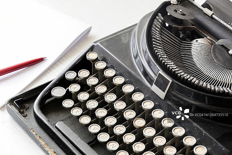 老式打字机，一张空白纸和一支红笔图片素材