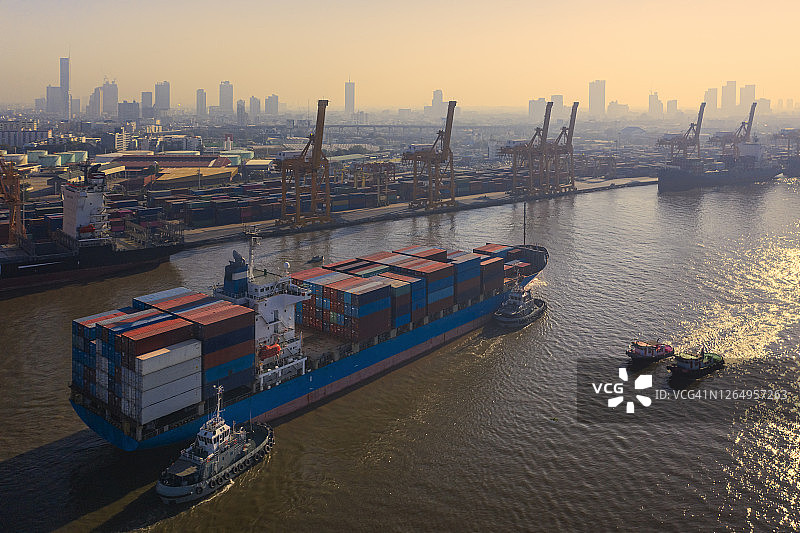 鸟瞰图集装箱货船前往码头商业港口装卸集装箱，用于商业物流、进出口、航运或货运。图片素材