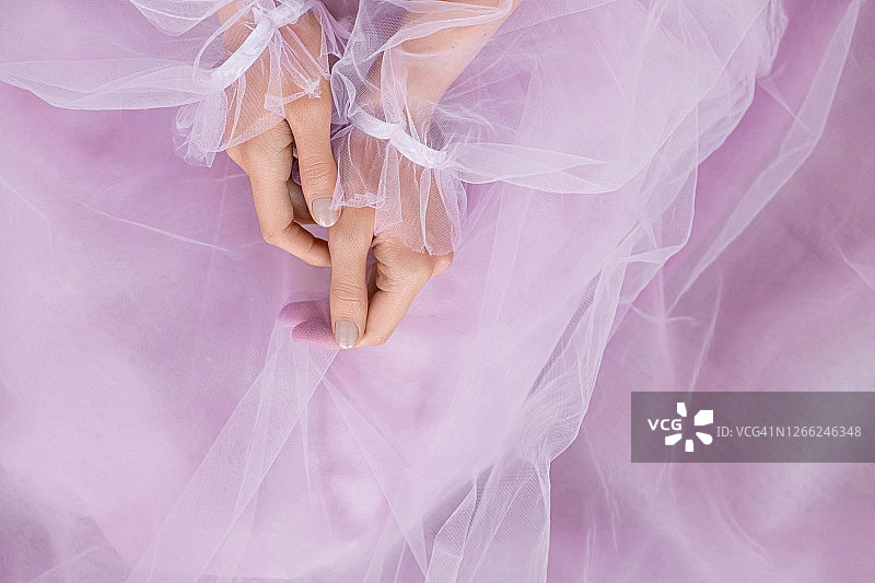 浅粉色指甲设计。女性的手有淡粉色的指甲。穿着粉红色衣服的女性，有淡粉色的指甲。图片素材