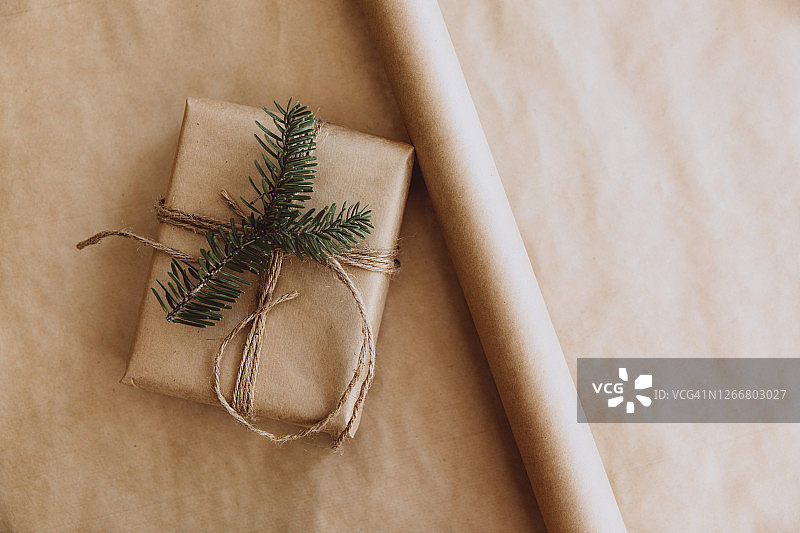 乡村风格的圣诞礼物。两个礼品盒，肉桂棒，松果，八角和松枝放在木桌上。前视图。图片素材