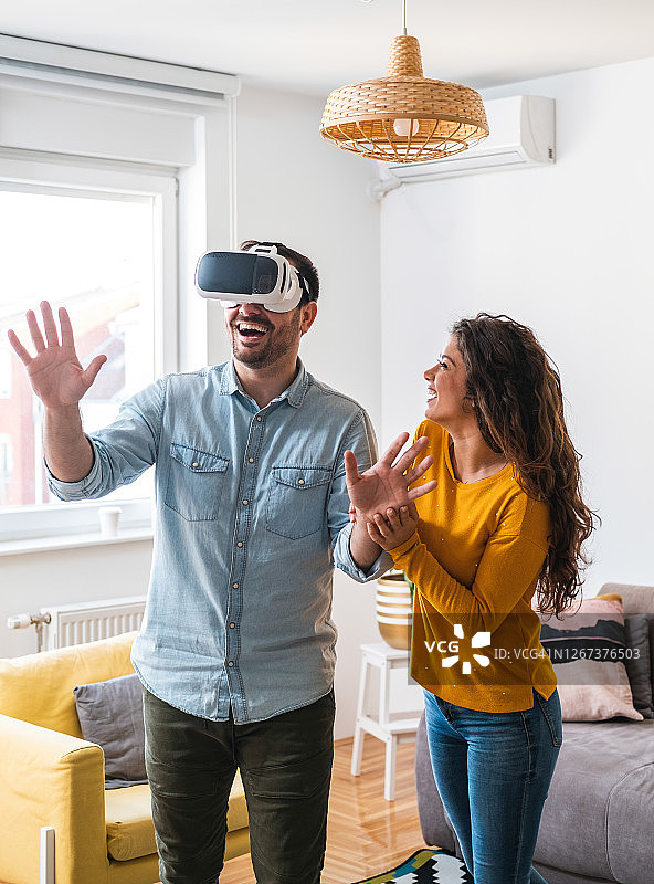 新婚夫妇用VR头盔在家库存照片图片素材