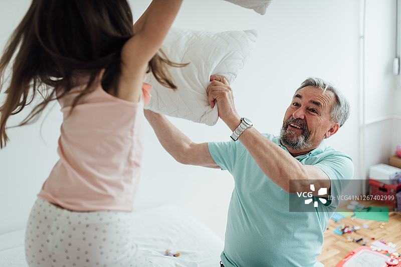 老男人和他的孙女在玩枕头大战图片素材