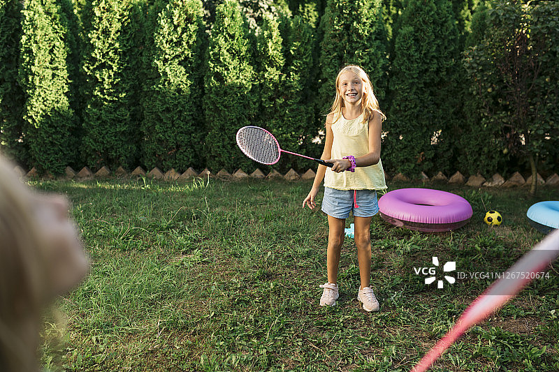 两个姐妹在后院打羽毛球图片素材