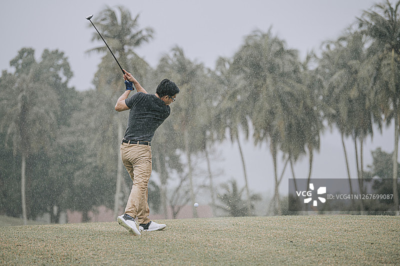 亚洲华人男子高尔夫球打在马六甲独自淋雨图片素材