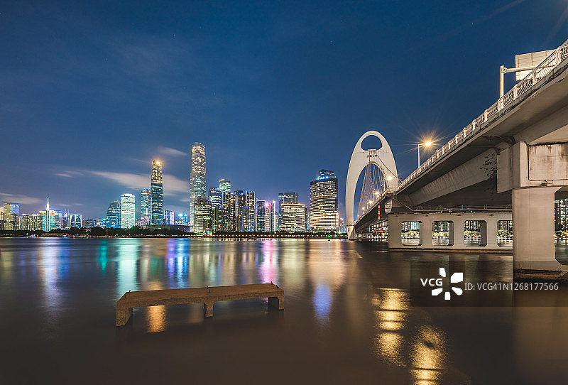 夜幕降临时，珠江两岸的城市建筑将两岸的桥梁连接起来。广州,中国。图片素材