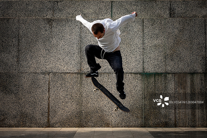 一个年轻人在城市里玩滑板图片素材