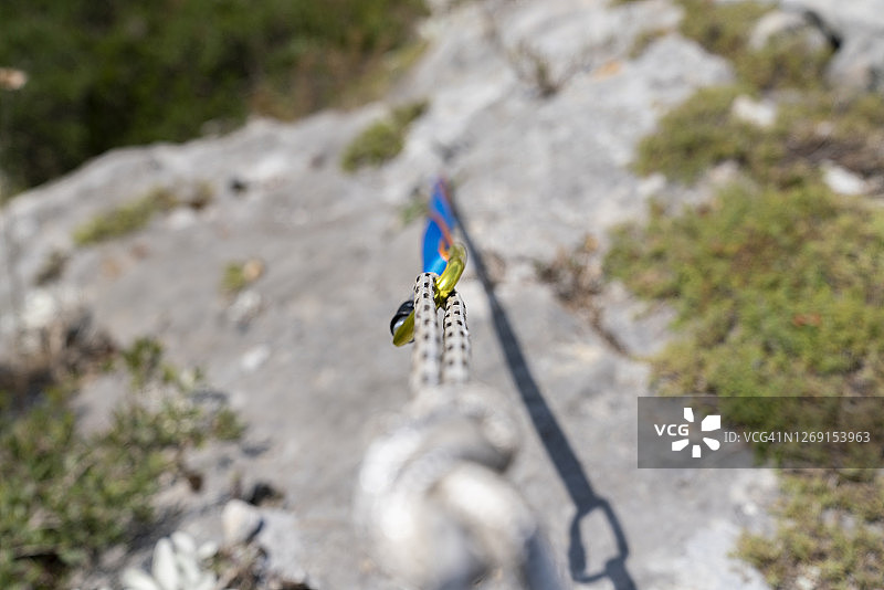 个人视角的登山装备包括钩环、背带、绳索和登山靴图片素材