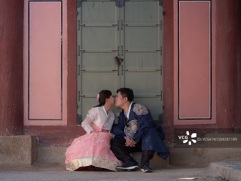 韩国首尔，一对亚洲夫妇在传统韩国大门前的韩服图片素材