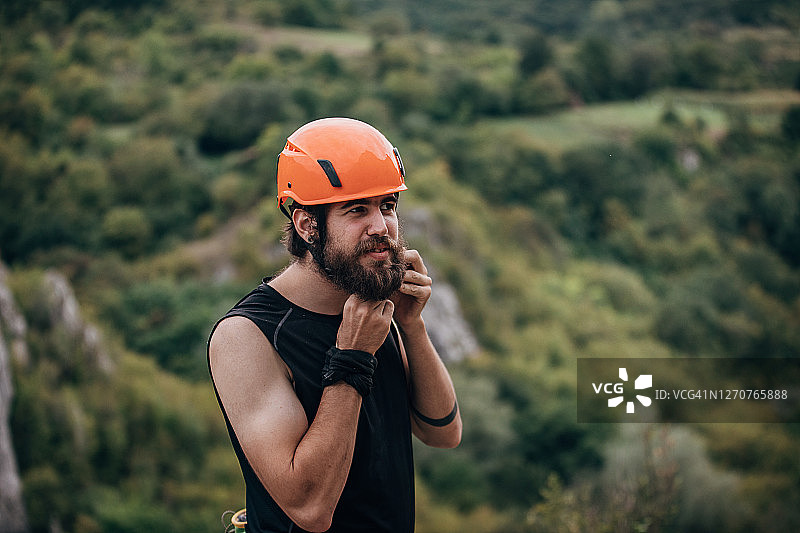 男子戴上头盔，准备攀登岩石图片素材