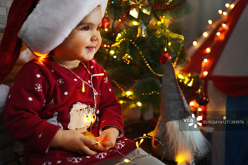 小女孩戴着红帽子的圣诞老人在圣诞装饰图片素材