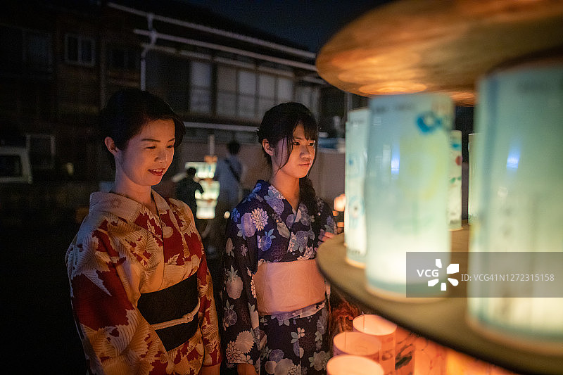 母亲和女儿在浴方看纸灯笼在传统的日本灯笼节图片素材