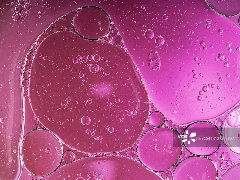 全框架的抽象形状和纹理形成的气泡和水滴在粉红色的液体背景。图片素材